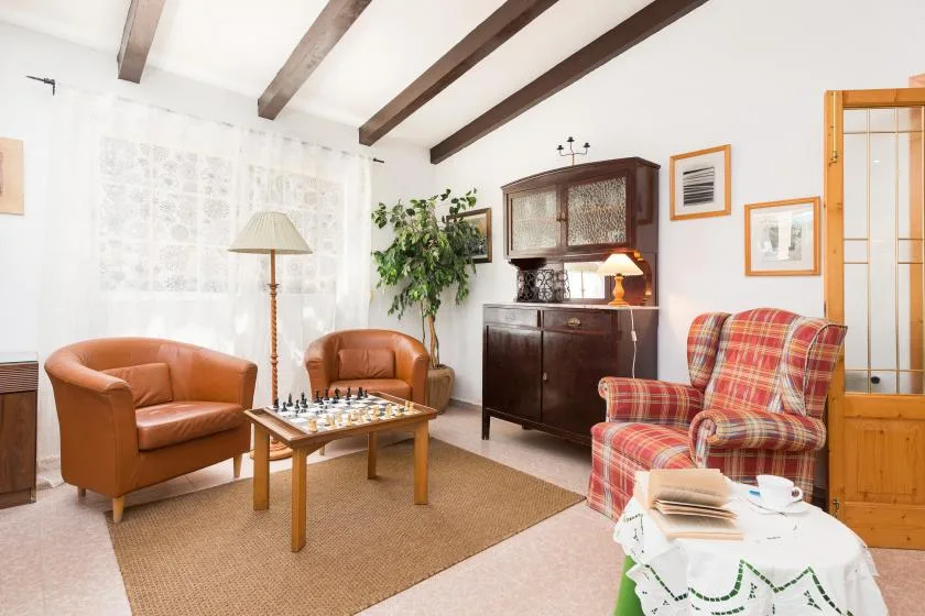 Una sala luminosa con asientos, un mueble de madera y una mesa pequeña.