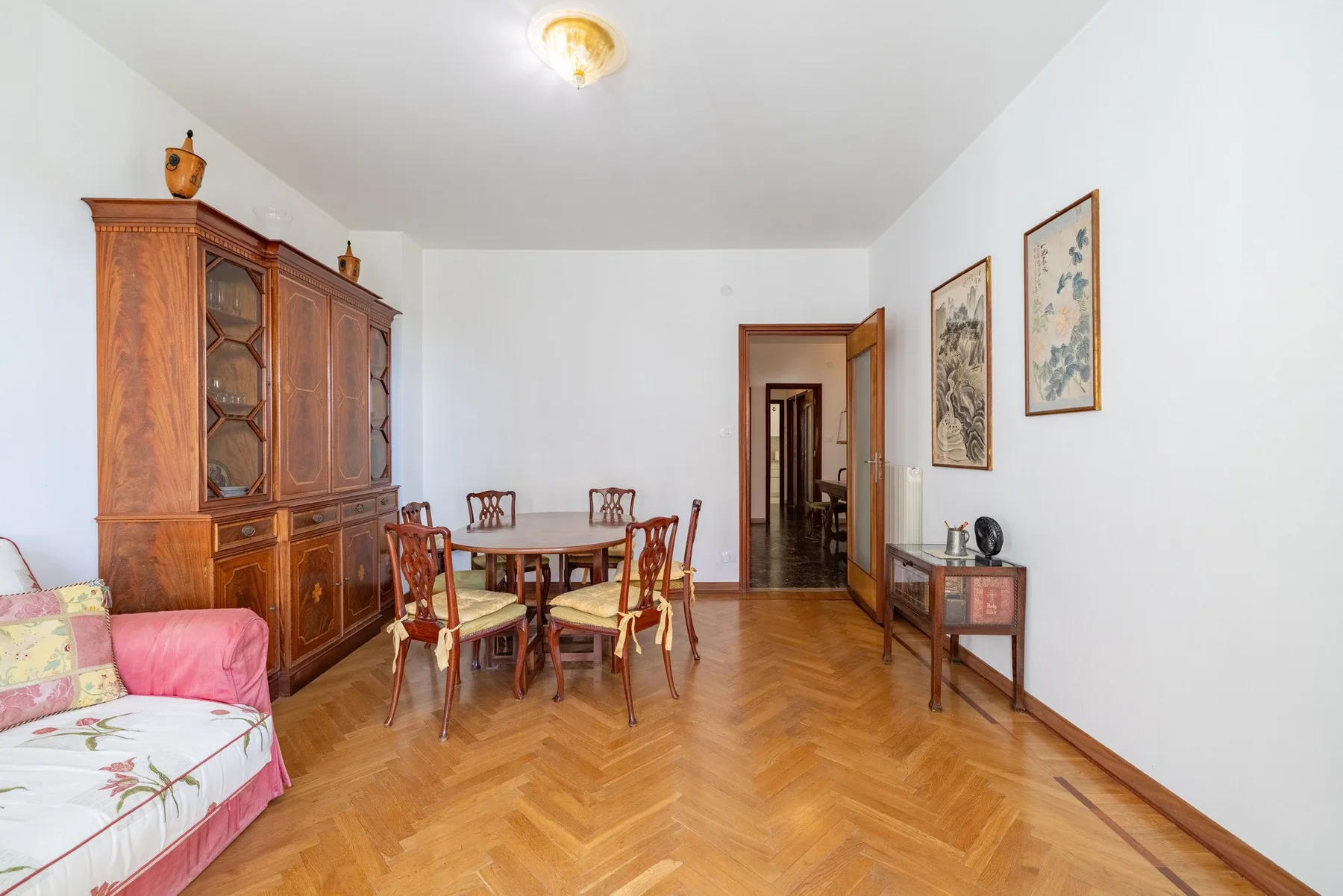A dining area with a wooden table and chairs beside a large cabinet.