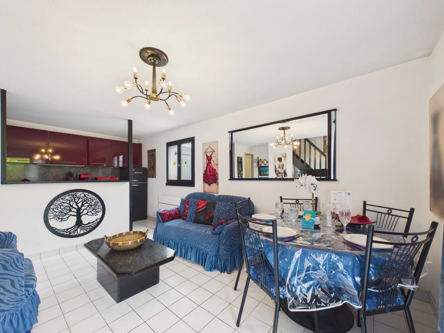 A living and dining room with blue seating and a table.