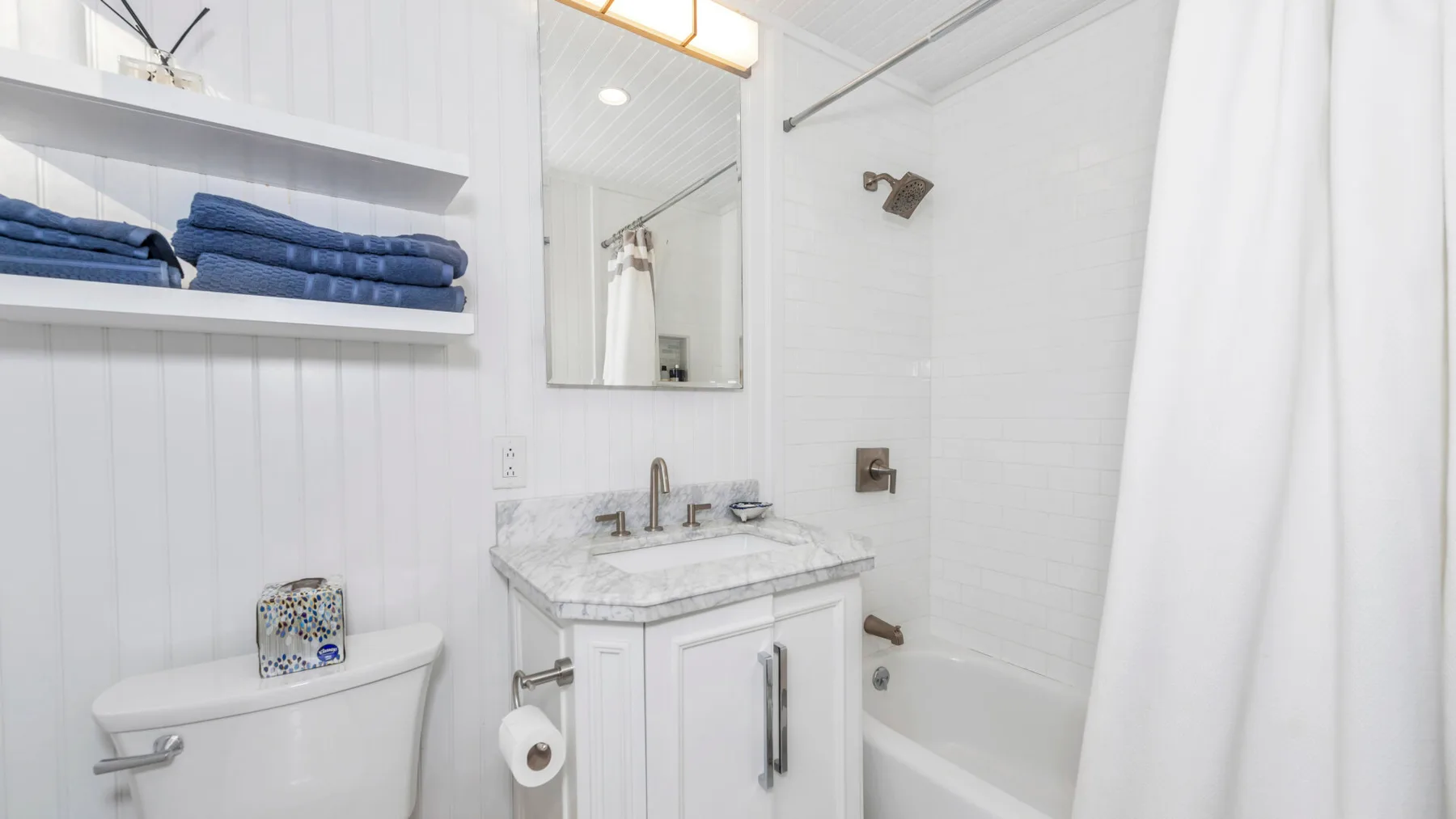 Un baño luminoso con lavabo, inodoro y bañera.