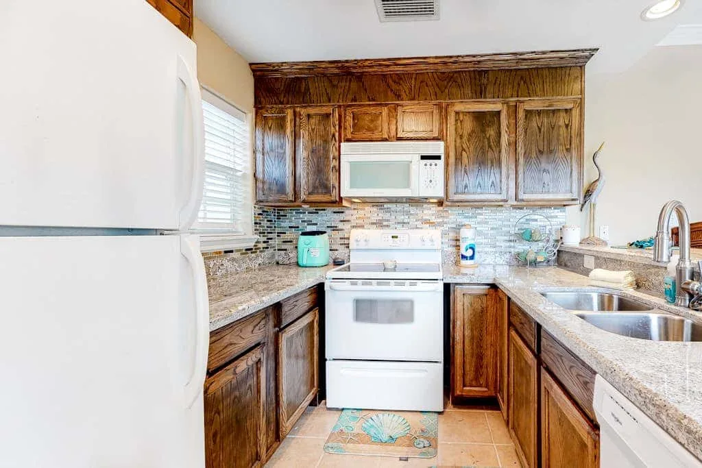A kitchen with wooden cabinets, a microwave, and a refrigerator.