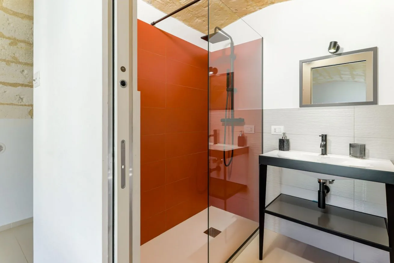 A modern bathroom with a glass shower and a wide vanity.