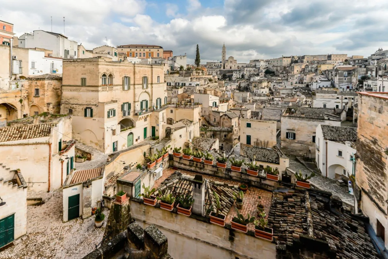 A dense hillside townscape of pale stone buildings and rooftop terraces.