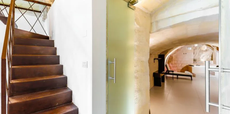 A staircase beside a low arched interior passage.