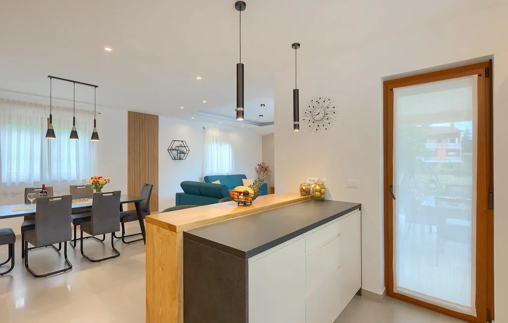 Una cocina y comedor de concepto abierto con una barra y una mesa.