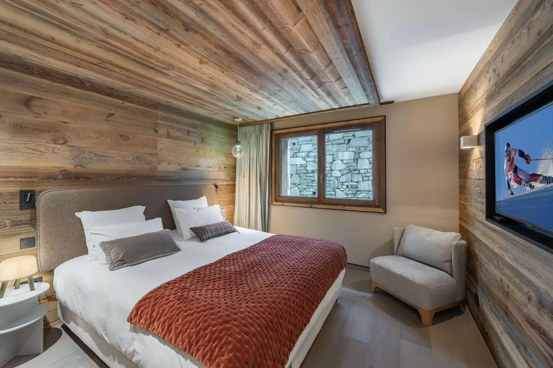 Bedroom with a bed, a window, and a cushioned seat beside the wall.