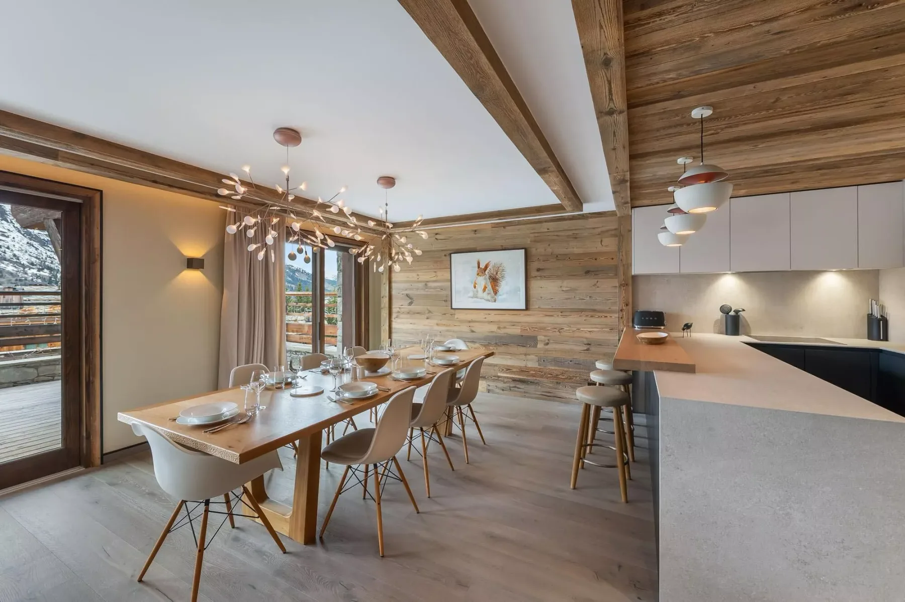 Comedor con una mesa larga junto a una cocina abierta.