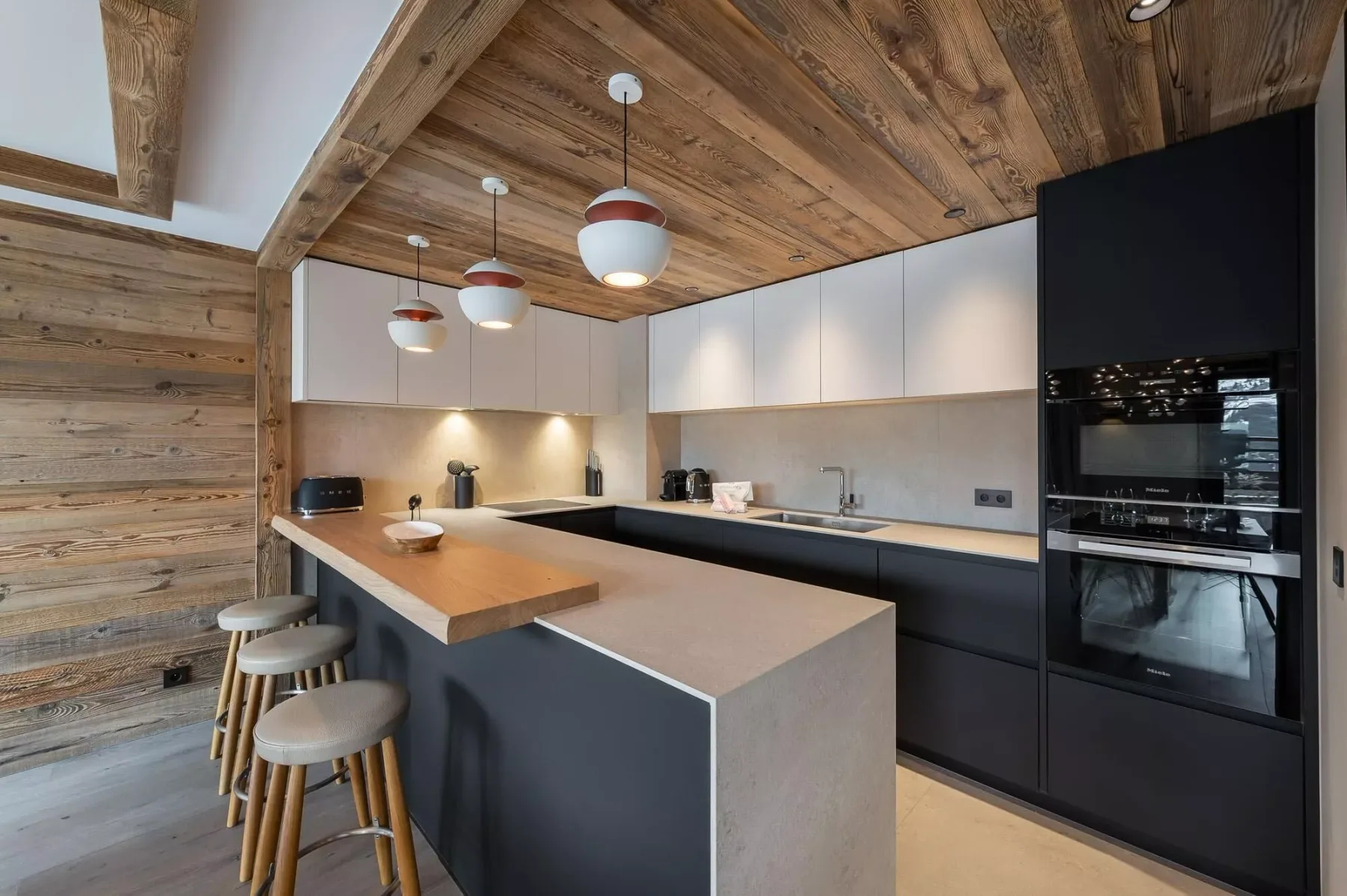 Una cocina moderna con una gran isla y lámparas colgantes.