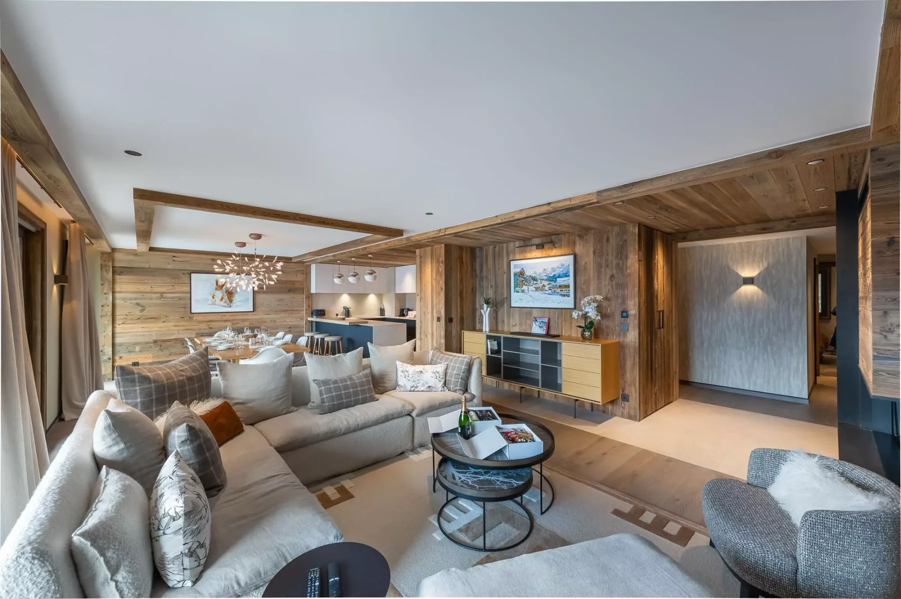 A wood-paneled living room with seating, a coffee table, and dining area.