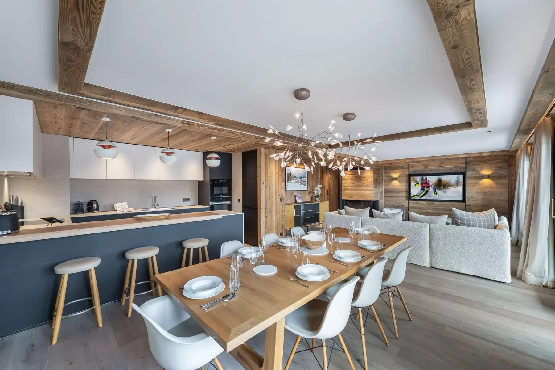 Una zona abierta de comedor y estar con una mesa de madera y una barra de cocina.