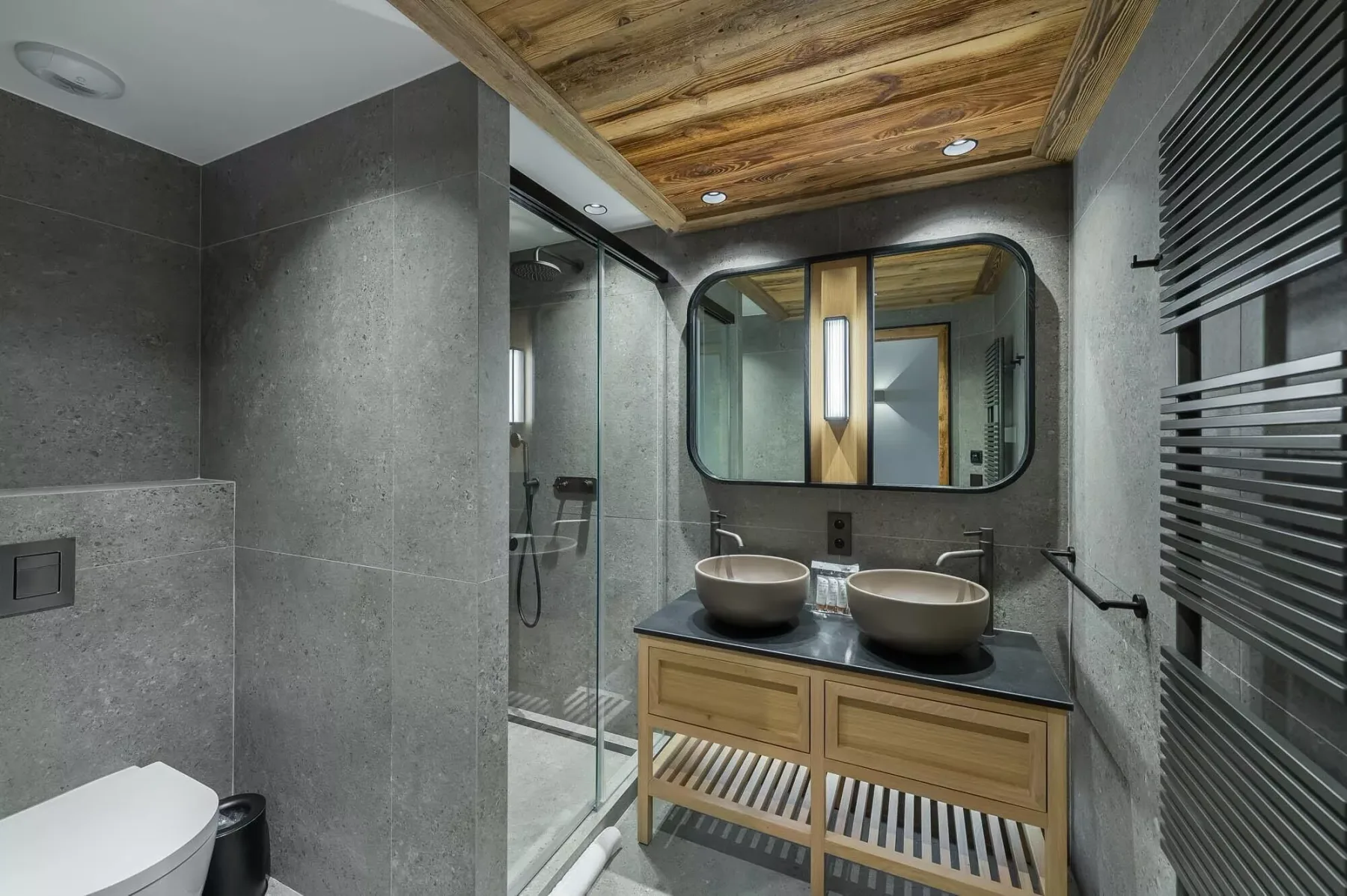 A modern bathroom with a double vanity and glass shower.