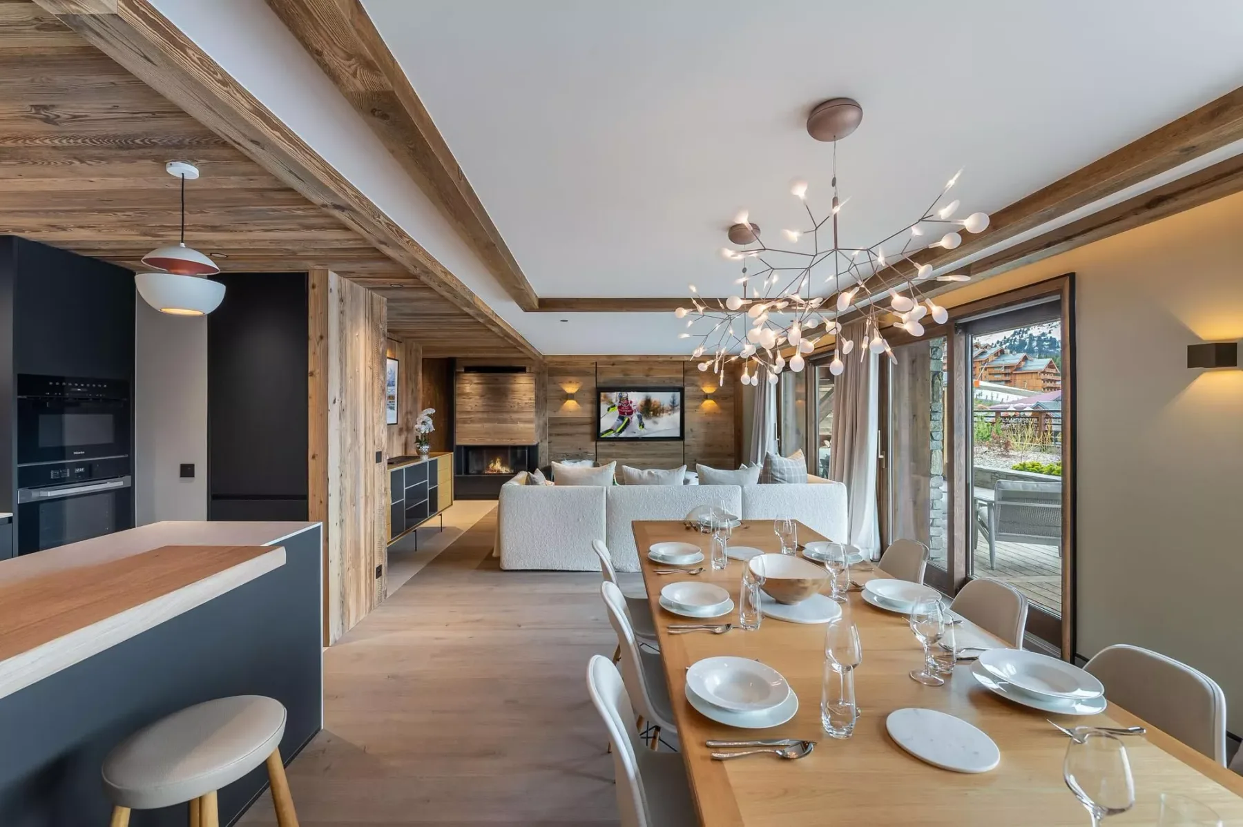 Sala de estar y comedor de concepto abierto, con una isla de cocina y ventanales.