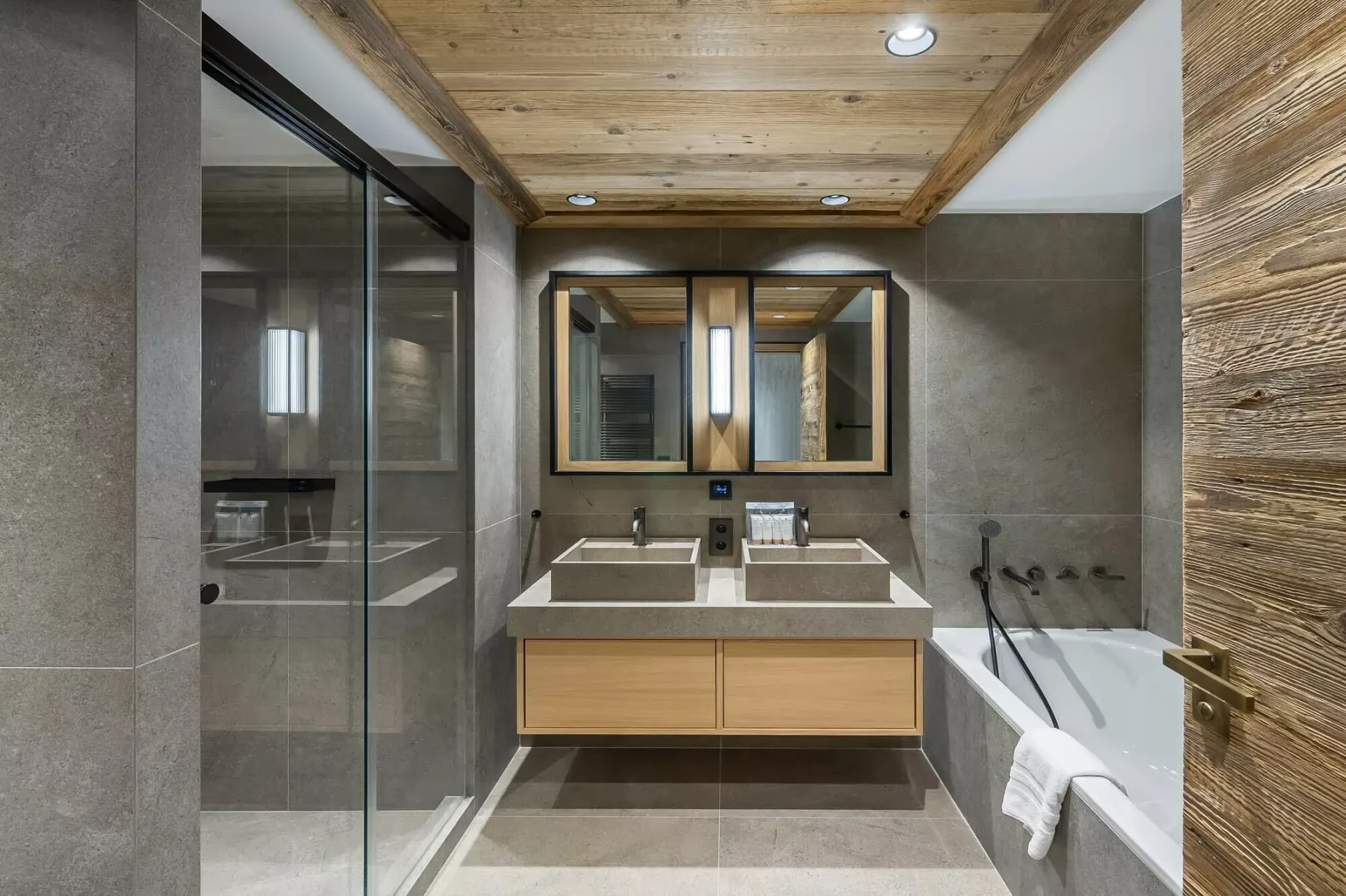 Un baño moderno con lavabo doble, bañera y ducha de vidrio.
