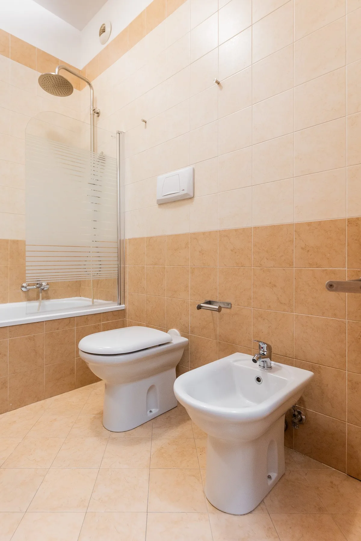 Un baño alicatado con bañera, inodoro y bidé.