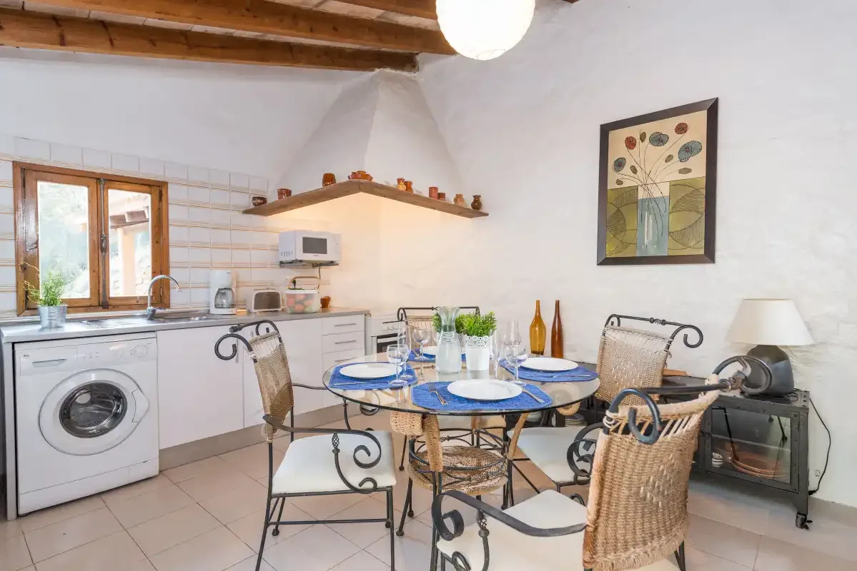 Una cocina y comedor con la mesa puesta junto a la encimera.