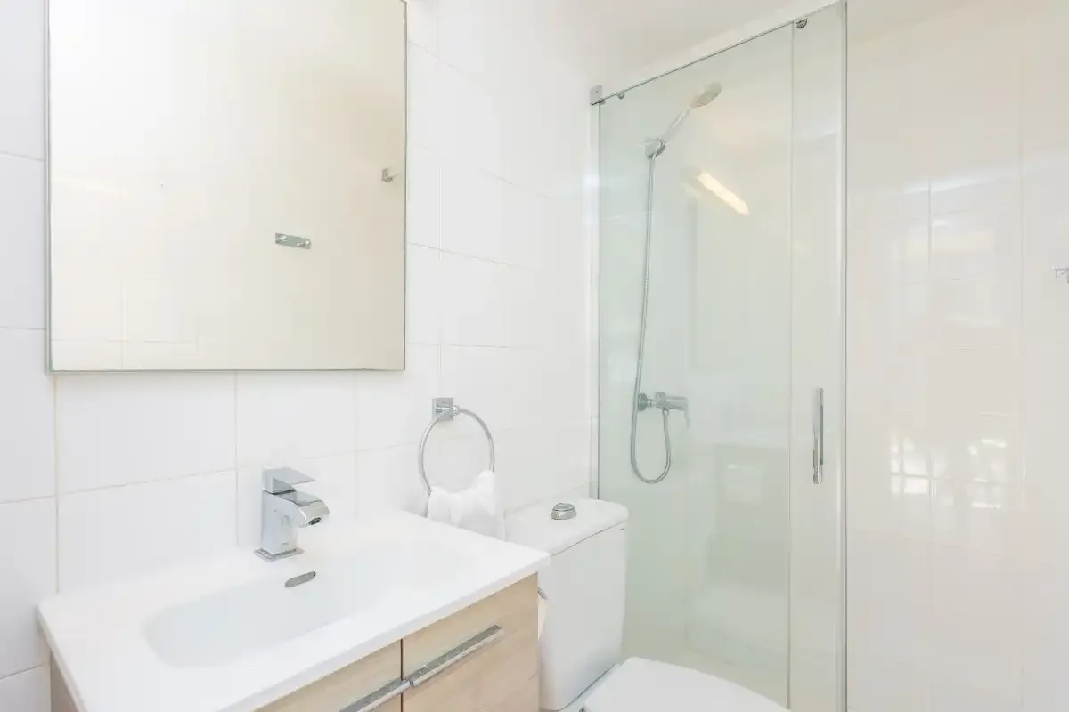 Un baño luminoso con lavabo y ducha.