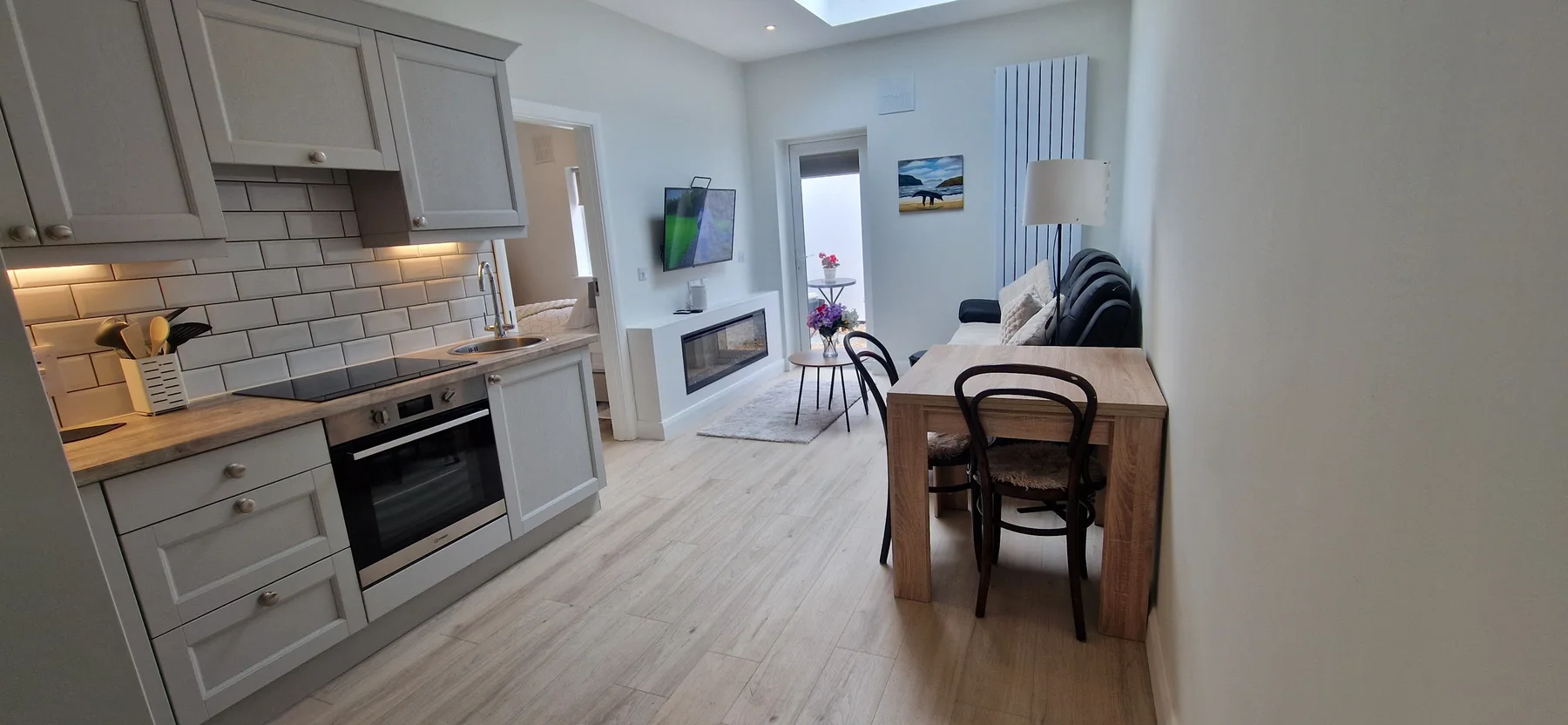 A bright open-plan kitchen and living area with a dining table.