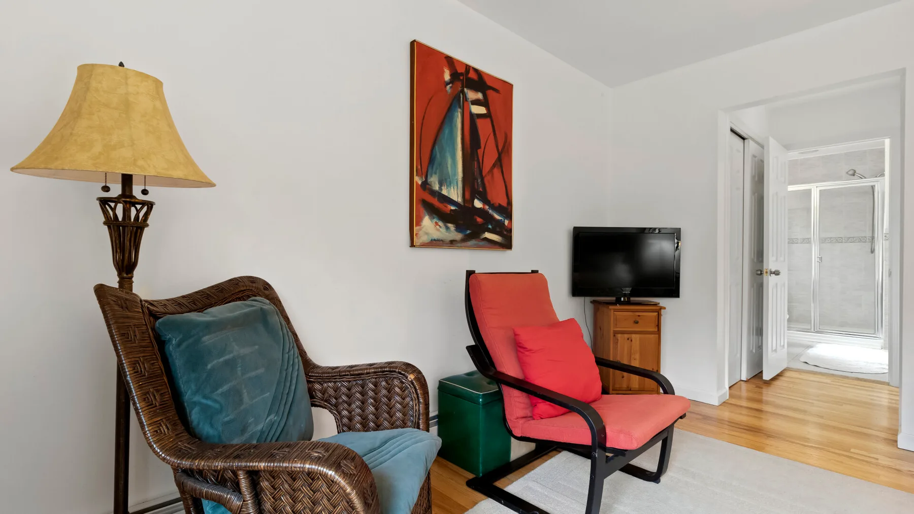 A living room with woven seating, a television, and an open doorway.