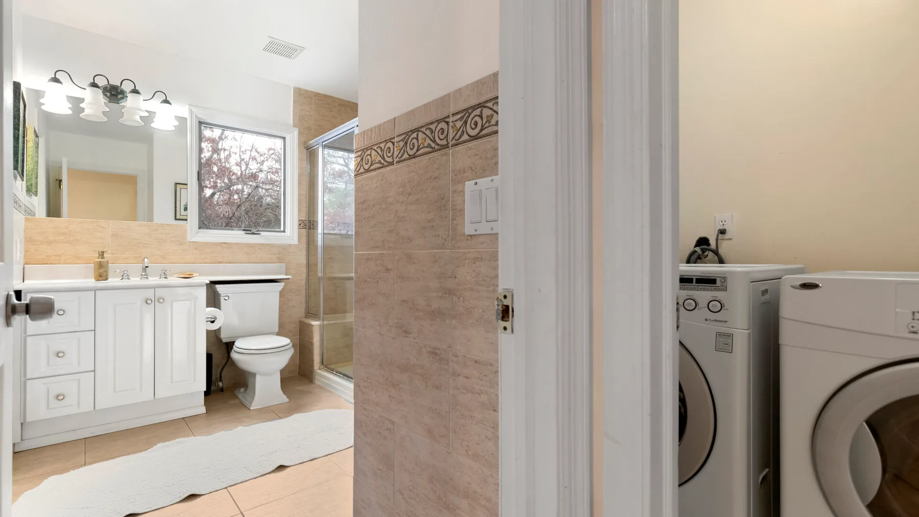 A bathroom with a vanity, toilet, and glass shower.