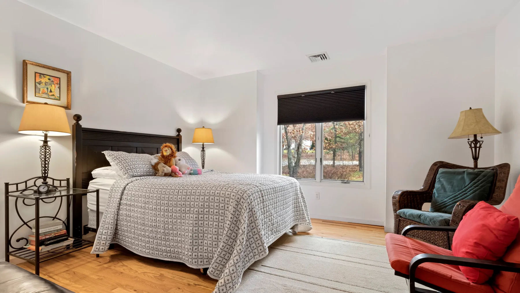 A bedroom with a bed, a window, and seating.