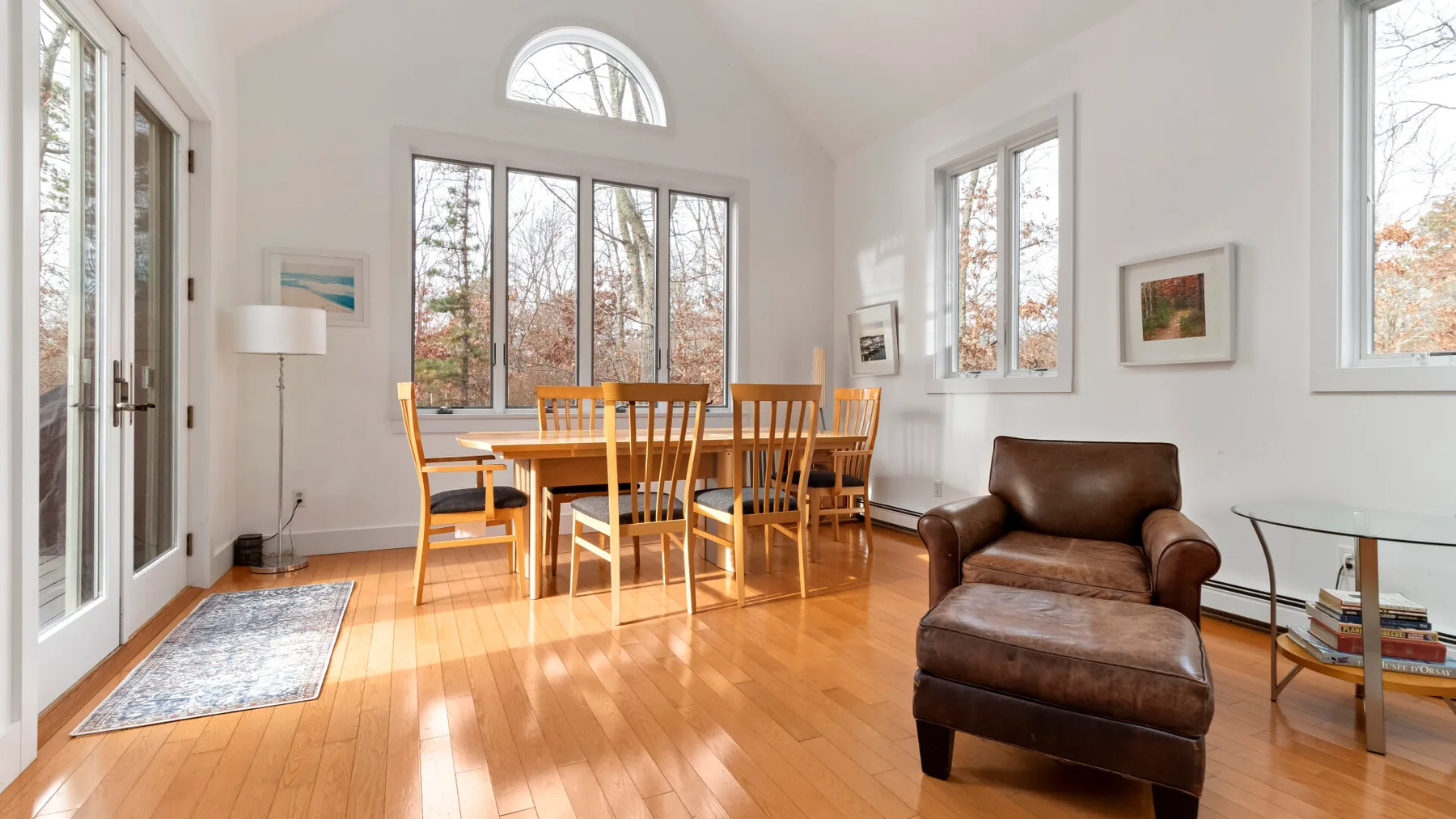 A bright dining and sitting area with a wooden table and leather seating.