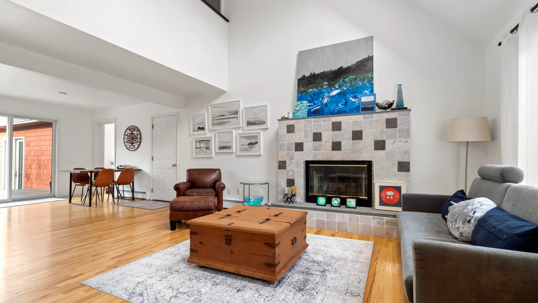 A bright living room with a fireplace, seating, and a wooden coffee table.
