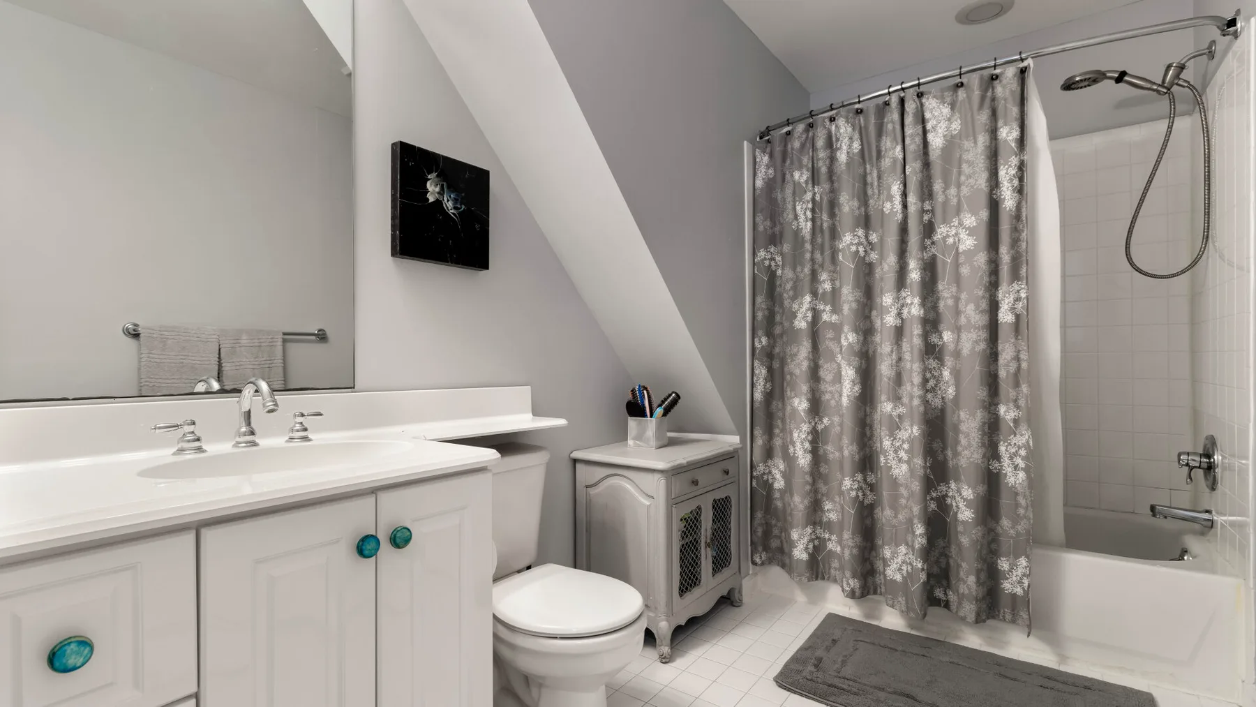 A bathroom with a long vanity, toilet, and curtained shower.