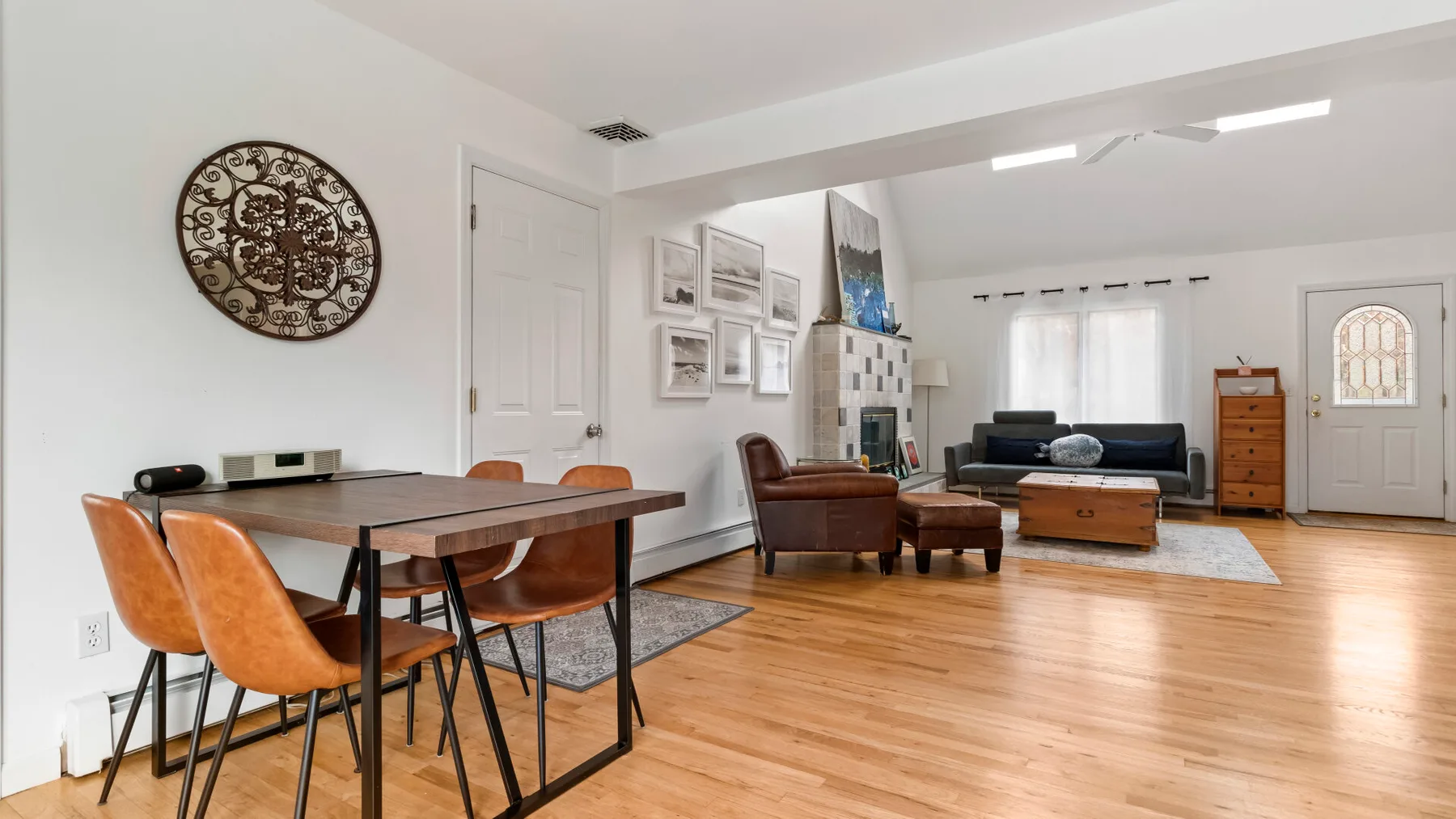A bright living and dining area with wooden flooring and seating.
