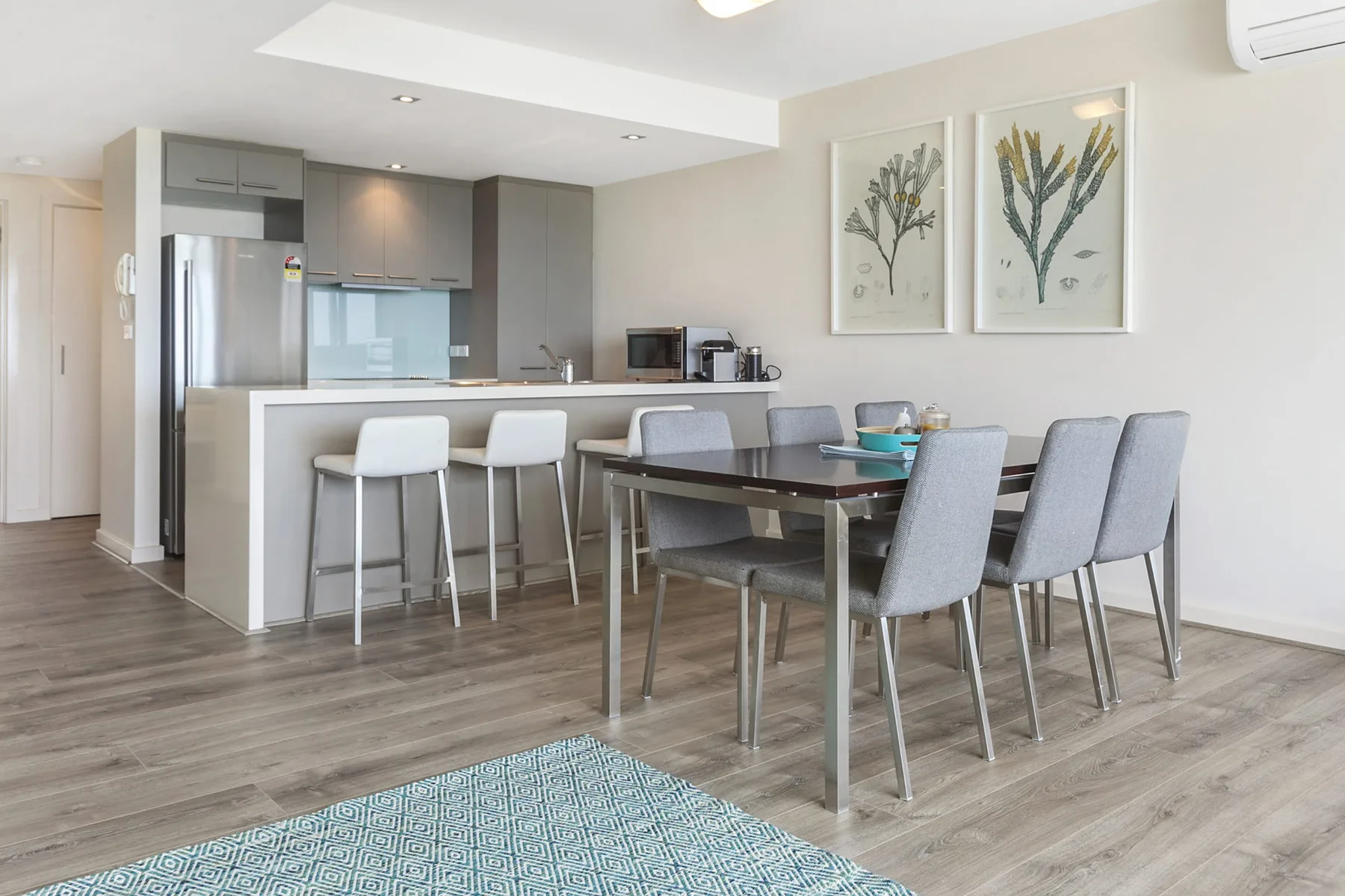 An open-plan dining area with a table beside the kitchen and counter seating.