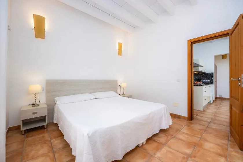 A bedroom with a neatly made bed and matching bedside tables.