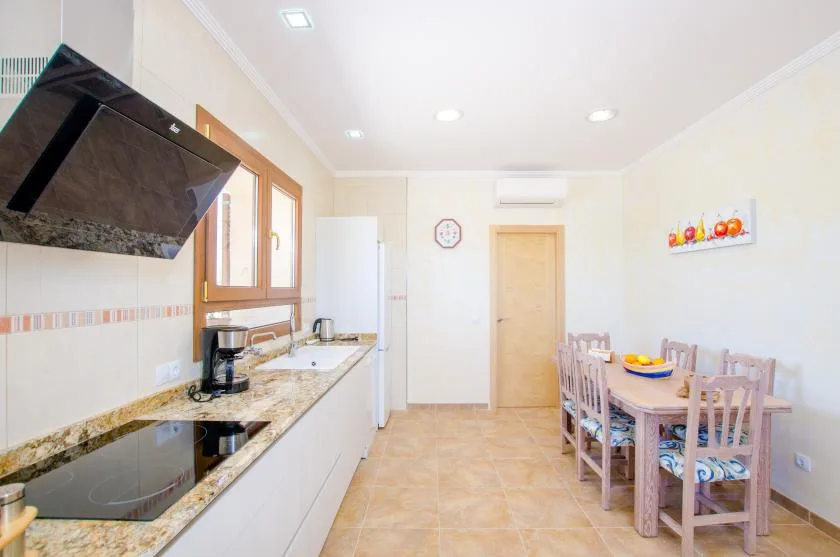 A bright kitchen with a dining table and countertop appliances.