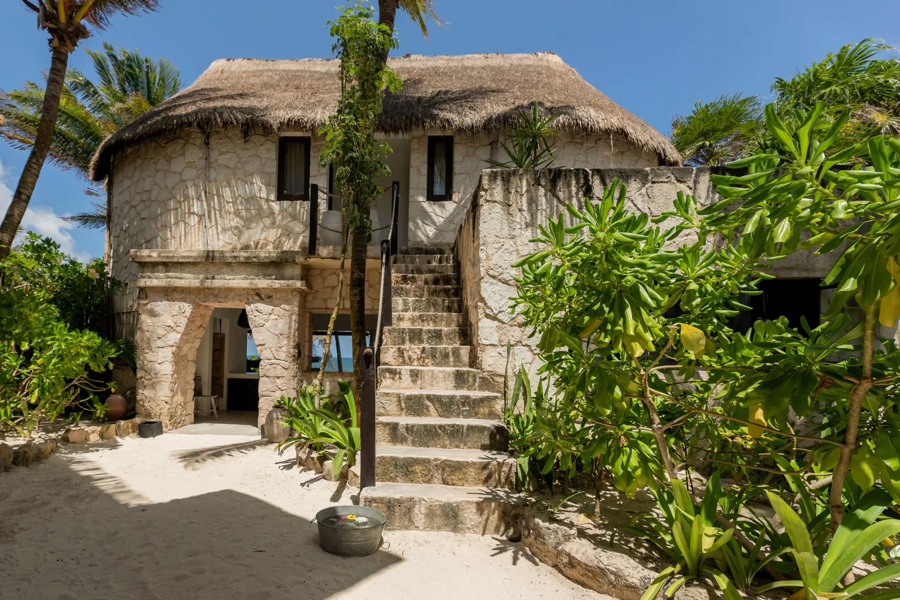 Stone villa exterior surrounded by tropical plants