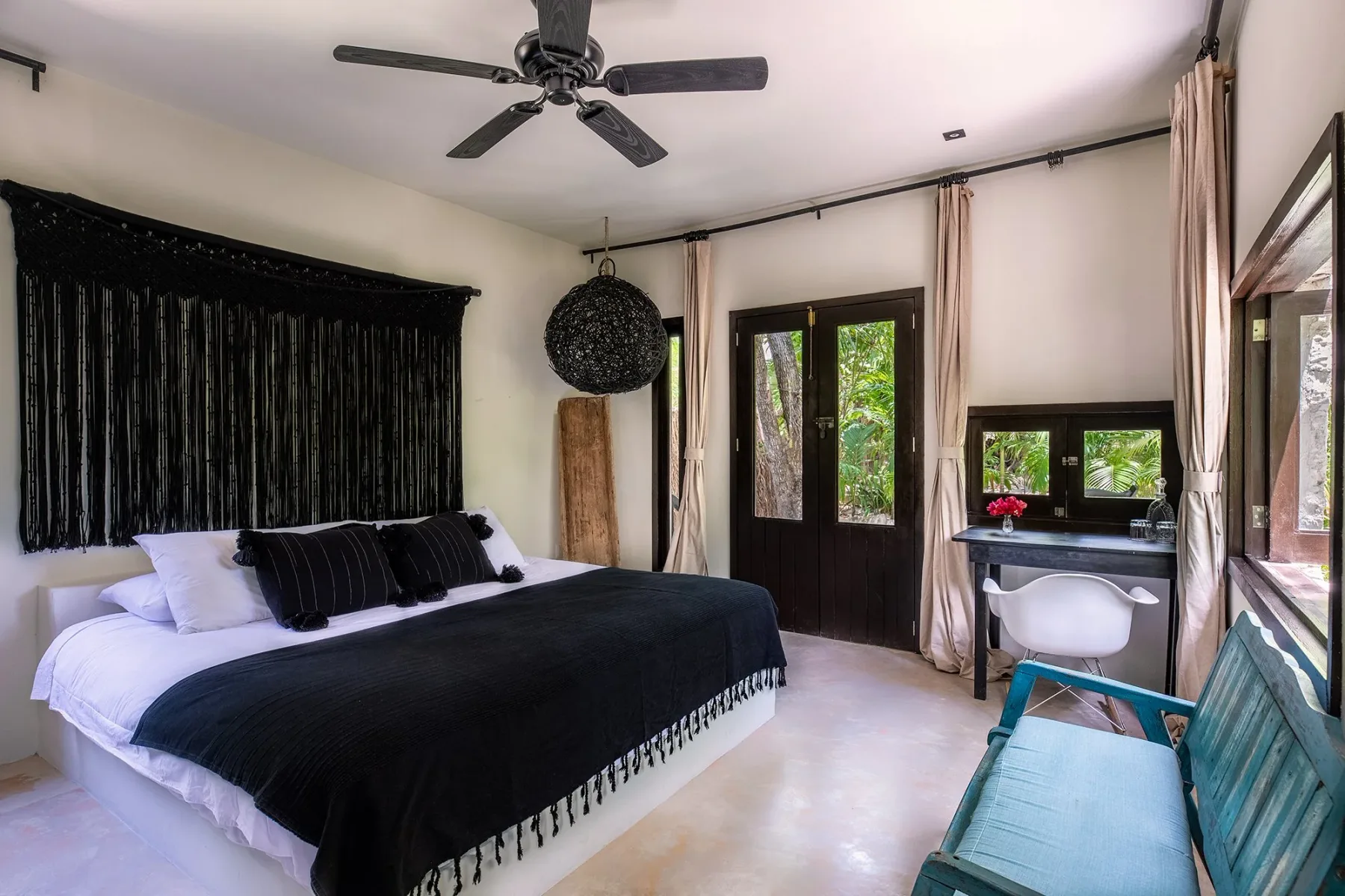 Guest bedroom with windows overlooking greenery