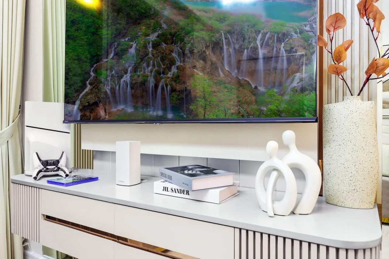Un mueble de sala está bajo un televisor que muestra una cascada.