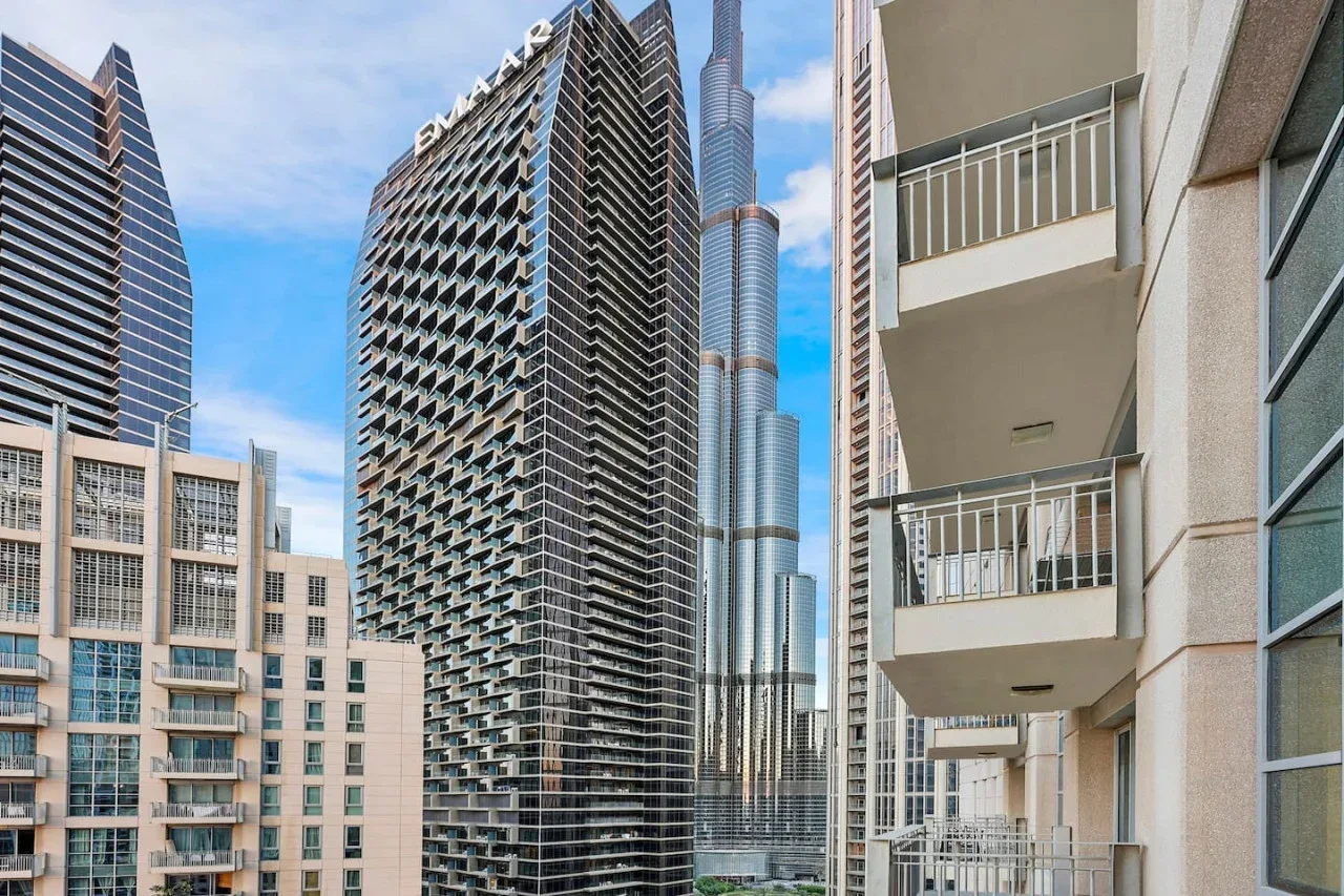 Un conjunto de edificios modernos de gran altura se alza bajo un cielo parcialmente nublado.