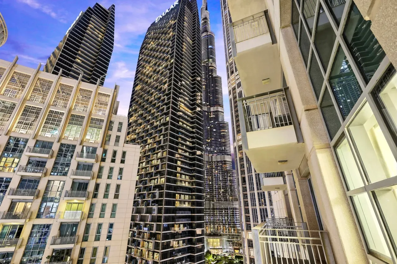 Una escena urbana con edificios modernos altos vistos desde abajo contra el cielo.