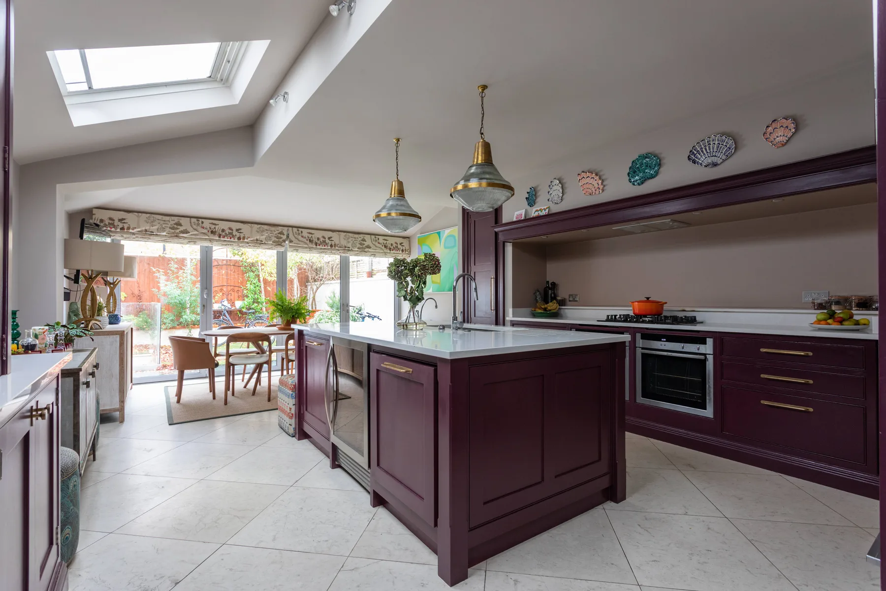 Una cocina amplia con isla central y comedor junto a las ventanas.
