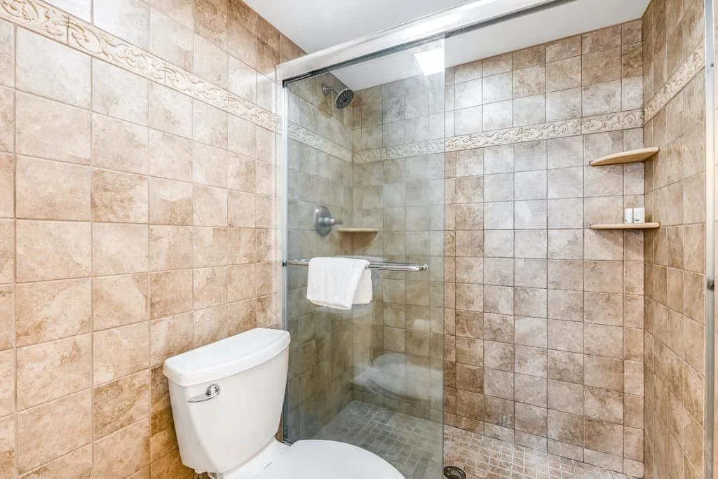 A tiled bathroom with a glass-enclosed shower and toilet.