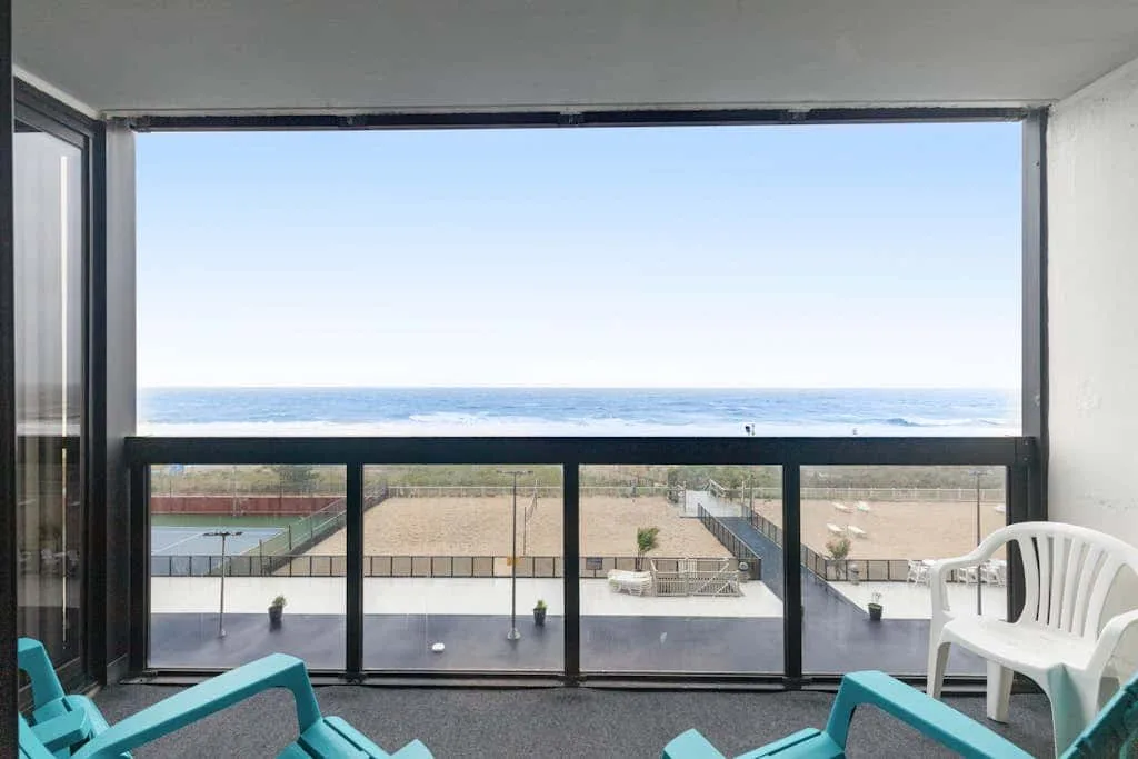 A balcony seating area overlooks the beach and ocean.