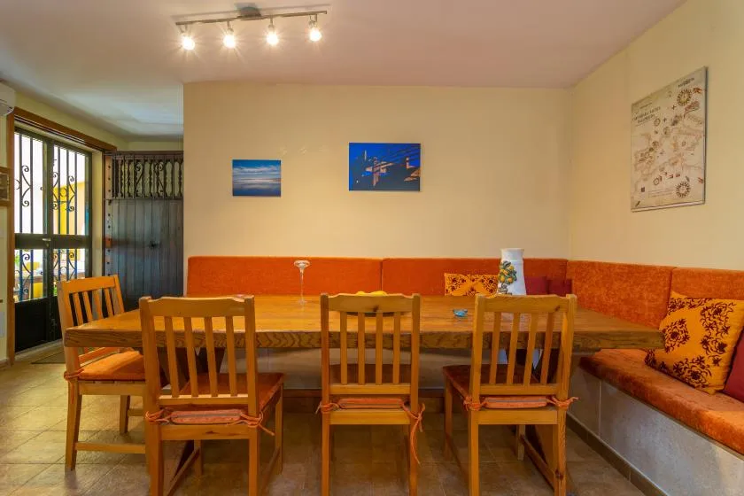 Comedor con una mesa de madera y sillas junto a asientos empotrados.