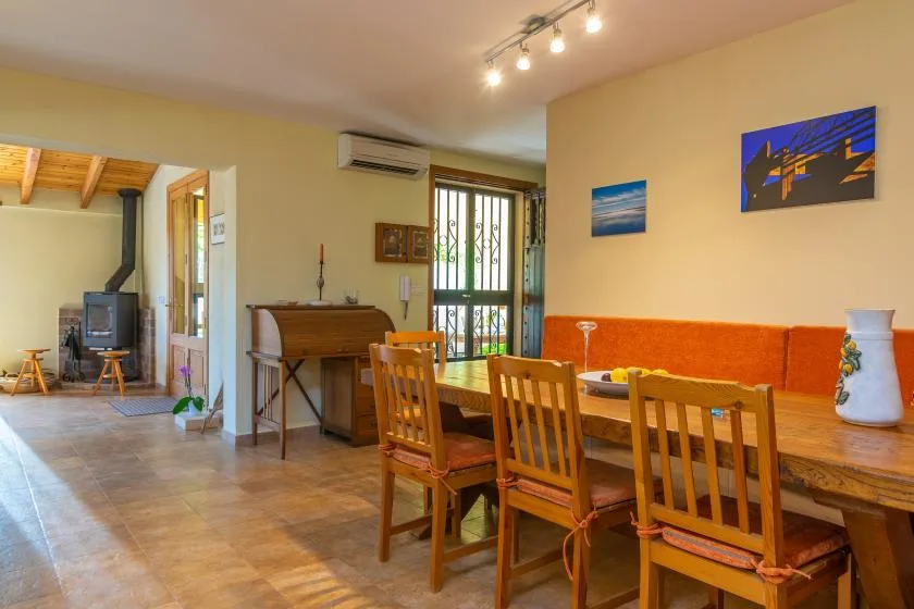 Comedor con una mesa larga de madera y sillas junto a una ventana luminosa.