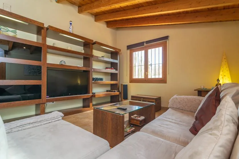 Una sala de estar con asientos, un televisor y una mesa de centro de madera.