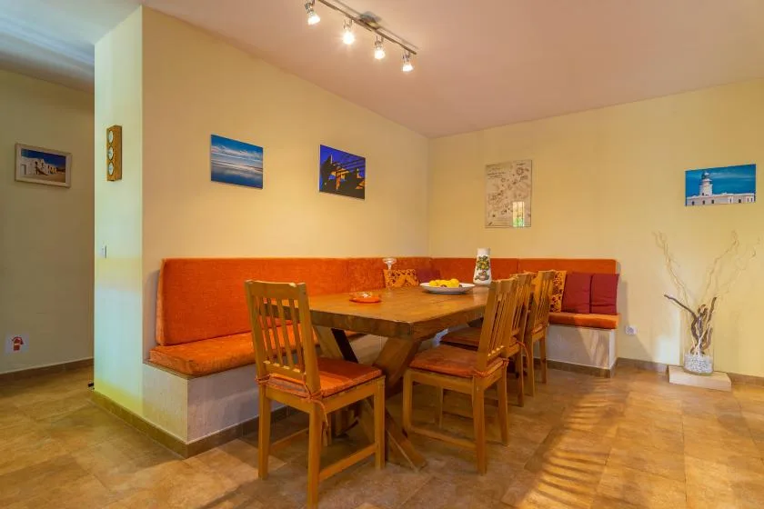 Comedor con una mesa de madera, sillas y asientos de banco integrados.