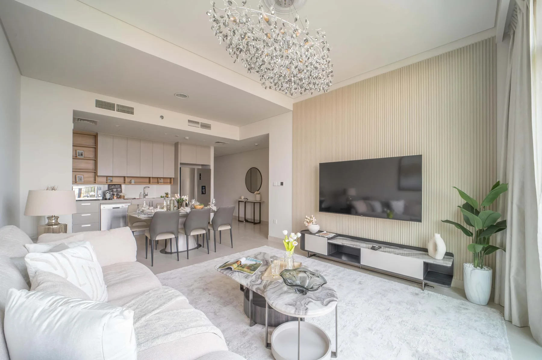 Una sala luminosa con asientos, un televisor y un comedor.