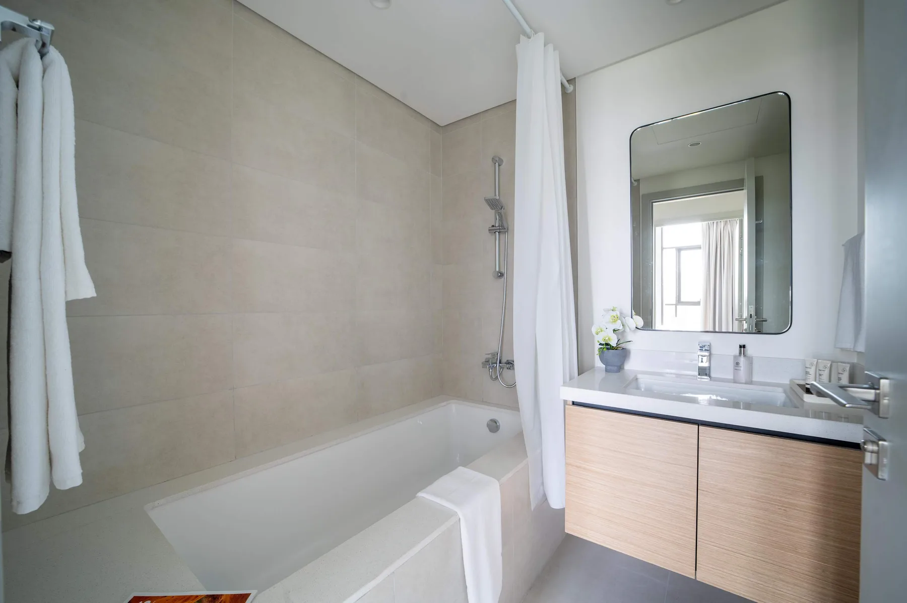 Un baño con bañera, ducha y lavabo bajo un espejo grande.