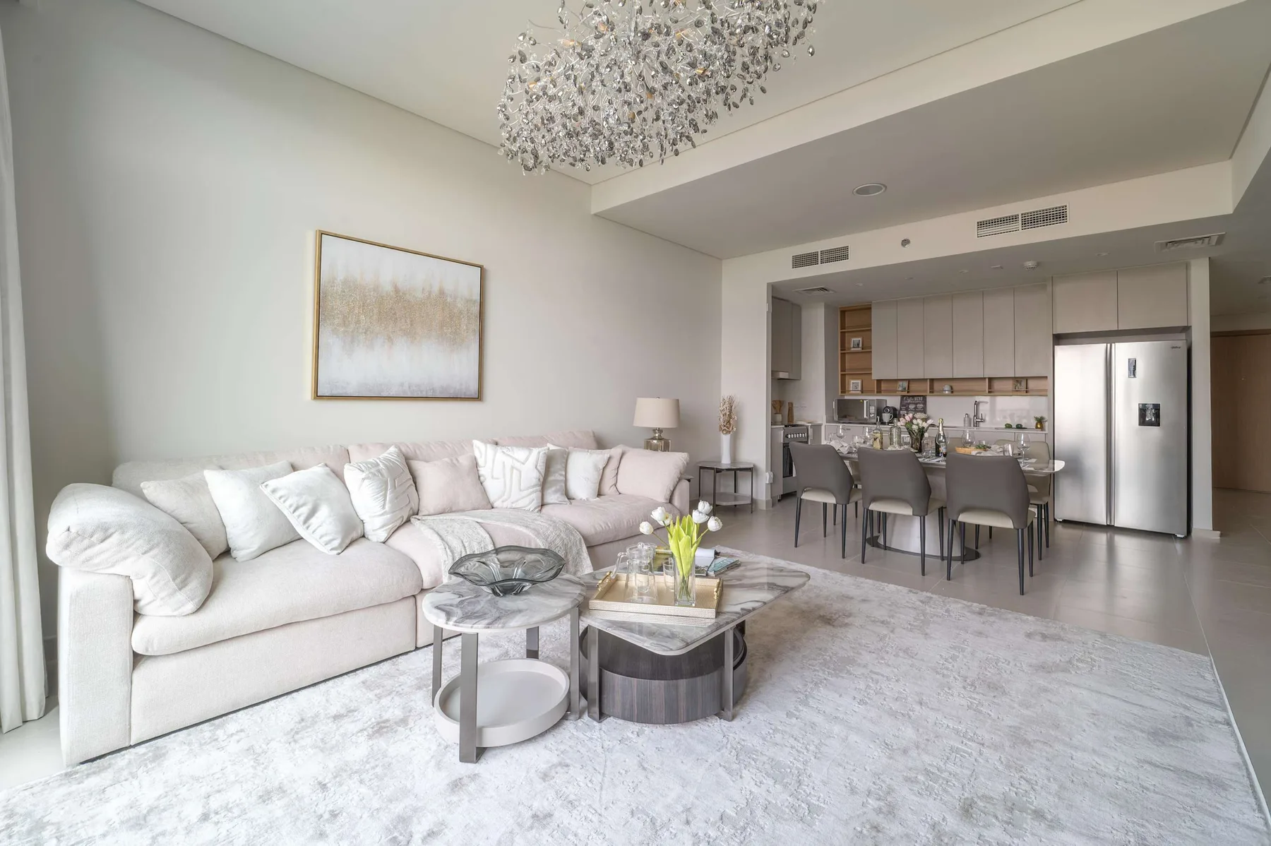 Una sala de estar y cocina de concepto abierto, con una zona de asientos clara y mesa de comedor.