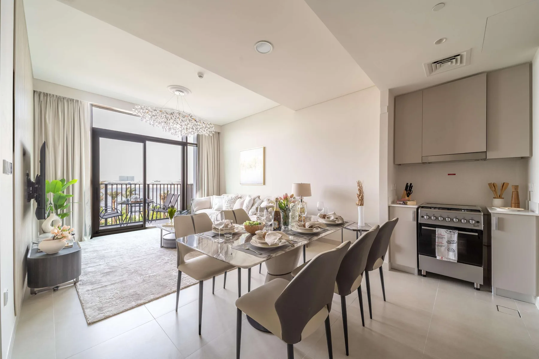 Un comedor luminoso con una mesa y asientos junto a una cocina abierta.