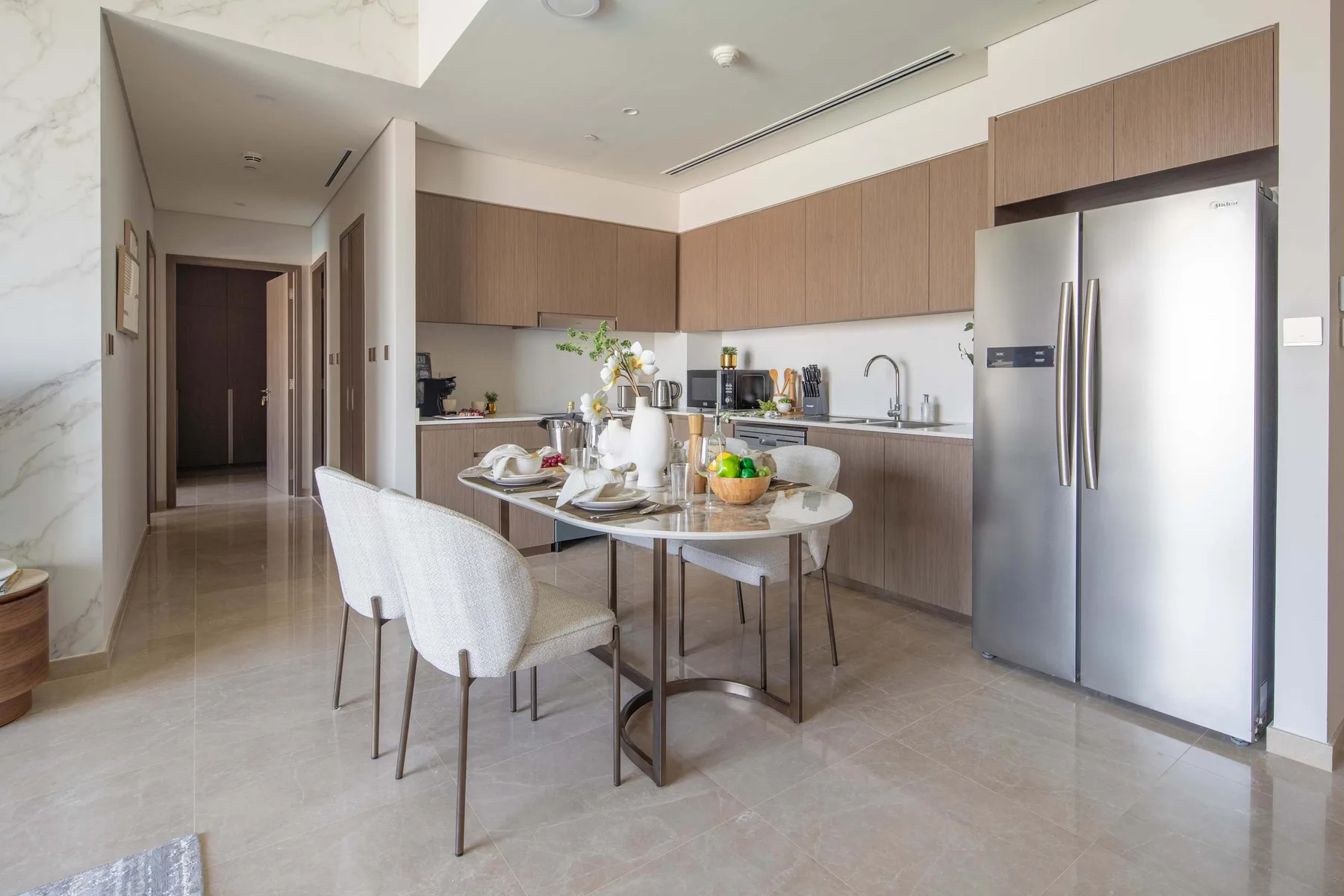 Una cocina moderna con mesa de comedor y refrigerador de acero inoxidable.