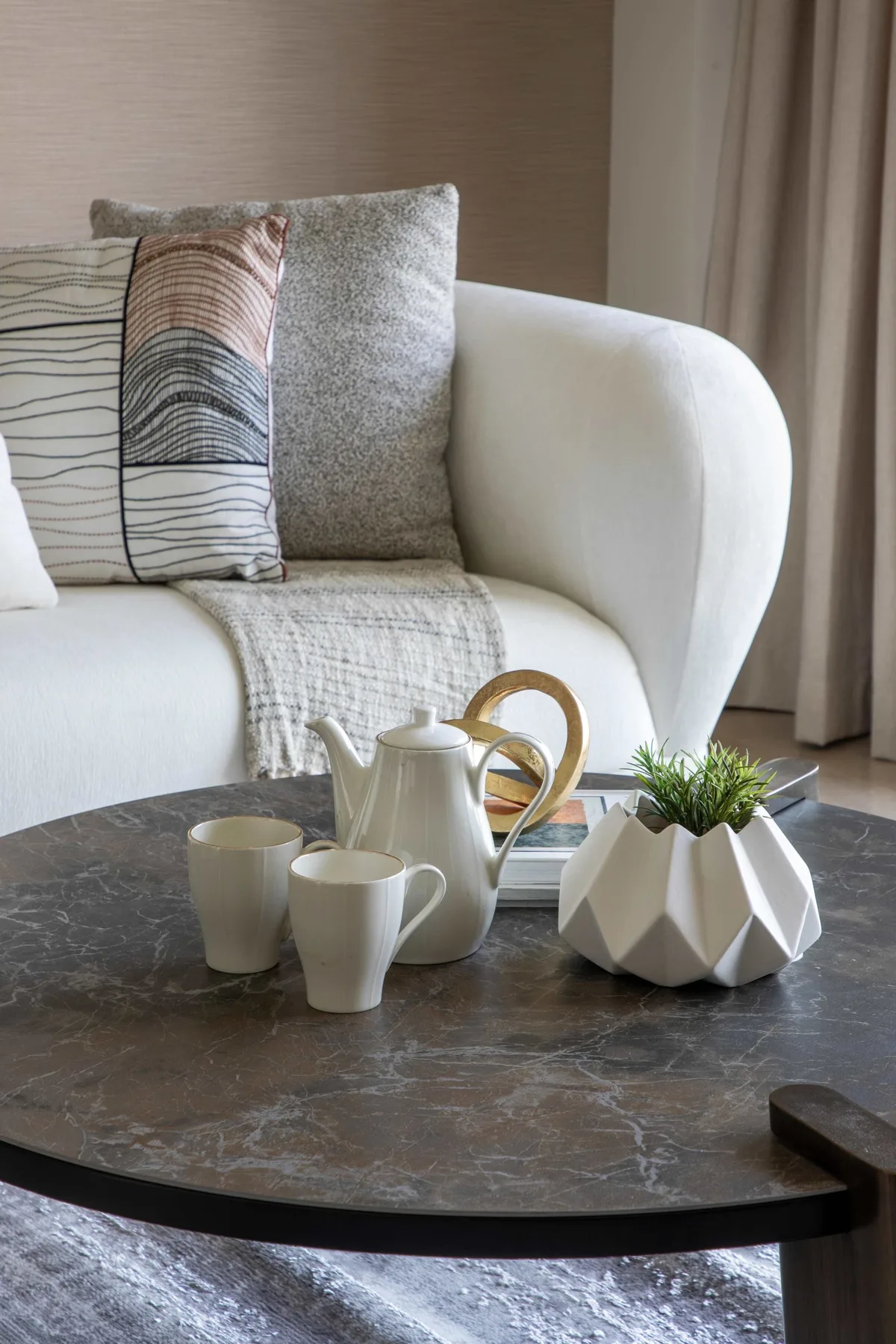 A living room seating area with a white sofa and a round coffee table.