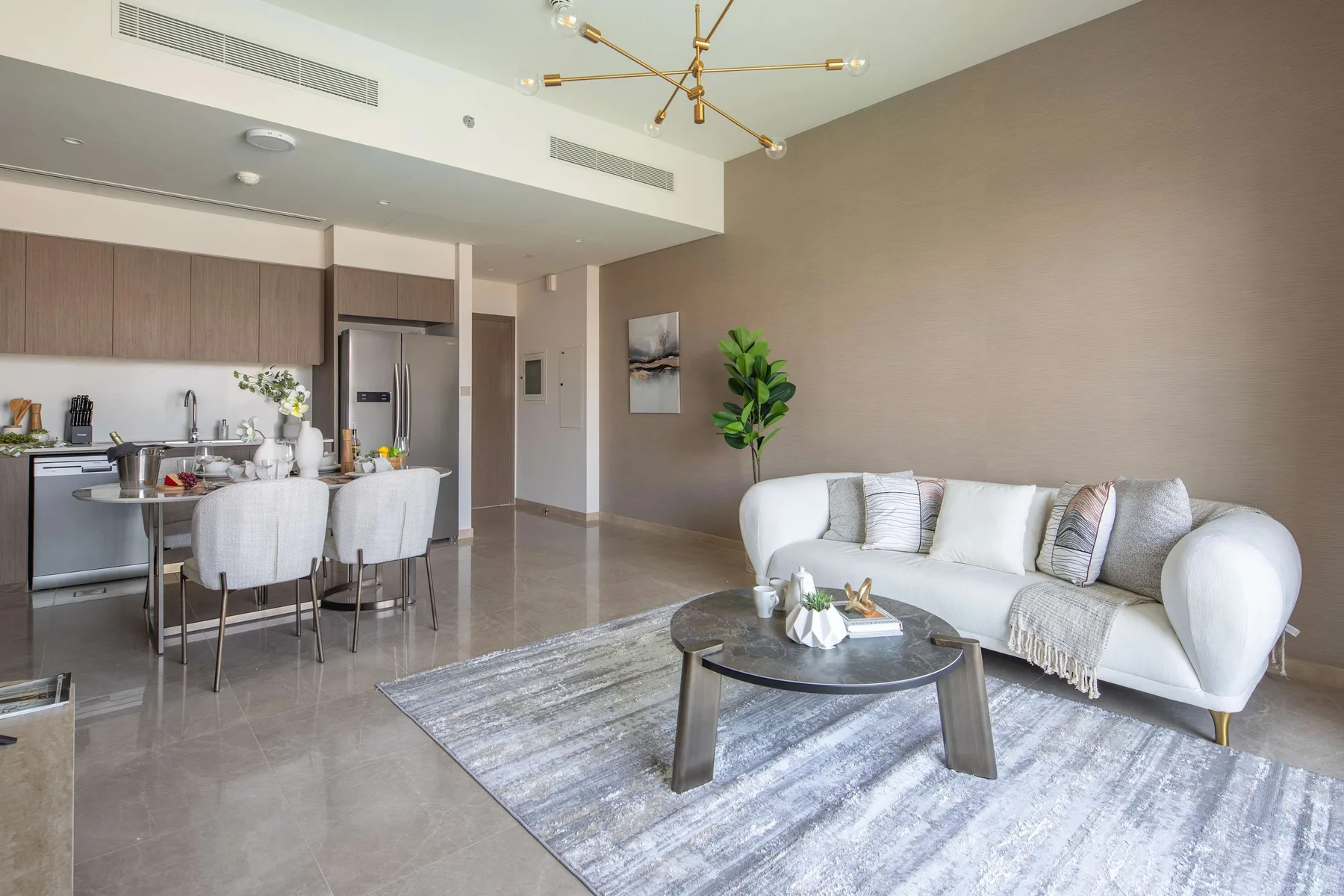 Sala y comedor de planta abierta con sofá, mesa de comedor y cocina.